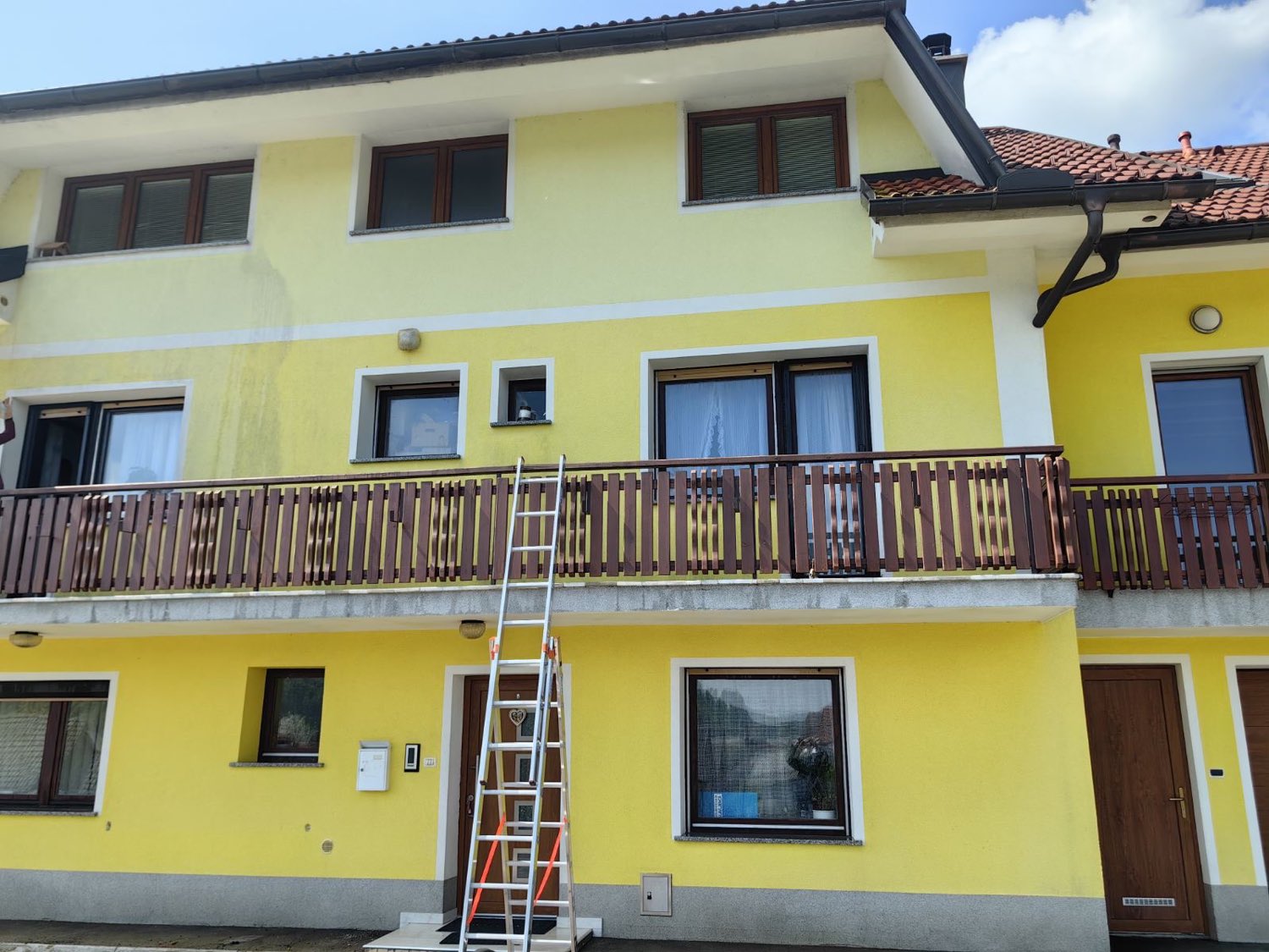 Čiščenje fasade večstanovanjske hiše z lestvijo