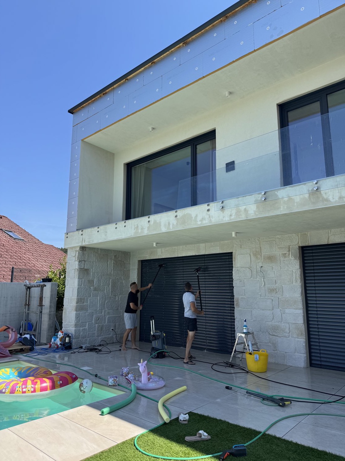 Ekipa Cleanik med čiščenjem steklene ograje in žaluzij na stanovanjski hiši